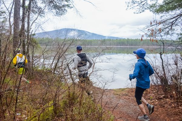 Runners on the lakeside trail with the mountains across White Lake