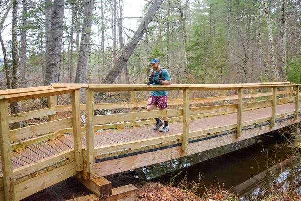 A runner crossing the wooden bridge