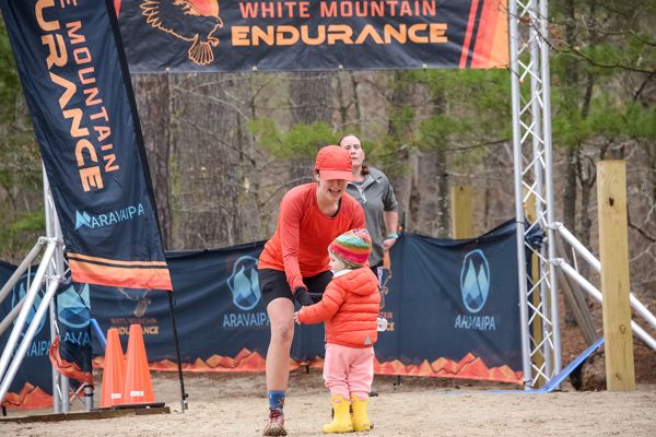 A runner and her daughter at the finish arch