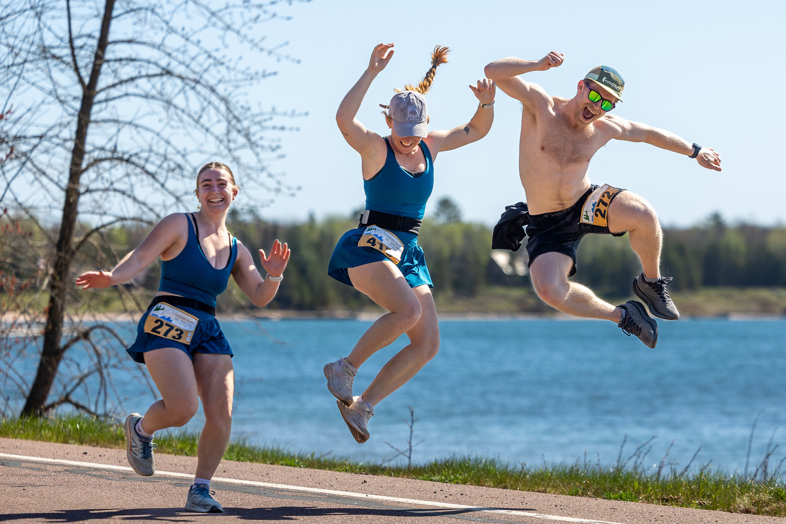 Three runners leaping along the Lake Superior shoreline